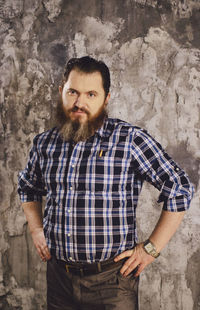 Portrait of man standing against wall