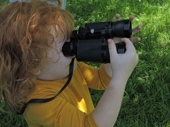 Girl holding binoculars in park