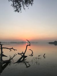 Scenic view of lake against sky at sunset
