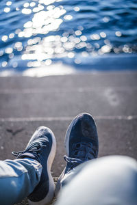 Low section of person on staircase by sea