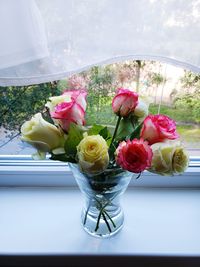 Close-up of roses in glass vase on table