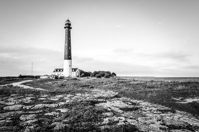 Low angle view of lighthouse on field against sky