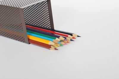 High angle view of multi colored pencils on white background