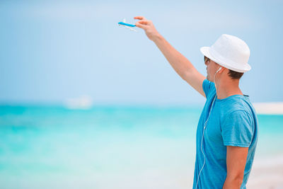 Midsection of man standing on beach against sky