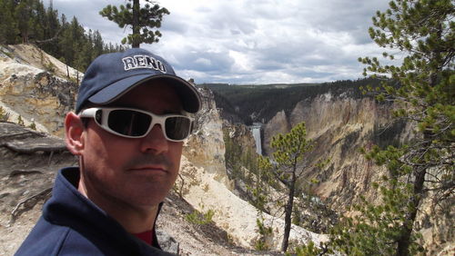 Portrait of man wearing sunglasses against mountains