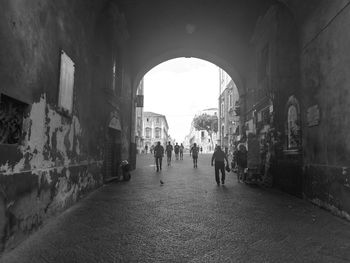 People walking on street amidst buildings in city