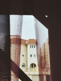 Low angle view of buildings seen through window