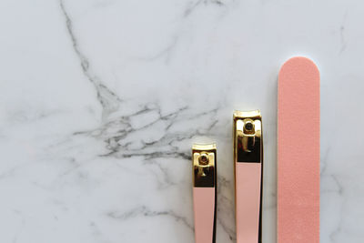 High angle view of nail clippers with file on marble table