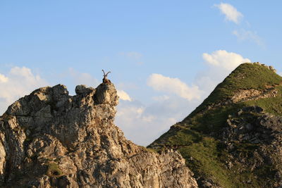 Low angle view of rocks on mountain against sky