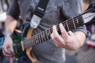 Midsection of man playing guitar