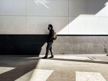 Full length of man standing against wall