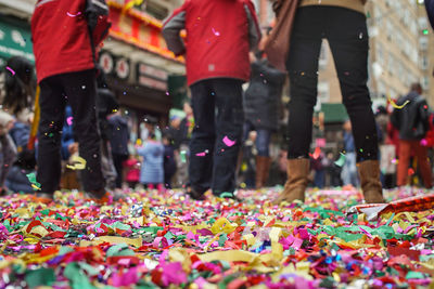 Surface level view of people on colorful confetti in city