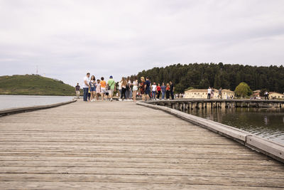 People walking on bridge against sky