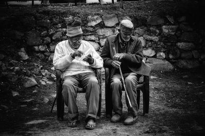 People sitting on bench against trees