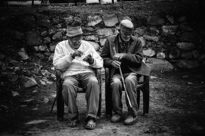 People sitting on bench against trees