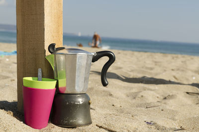 Close-up of sunglasses on beach against sky