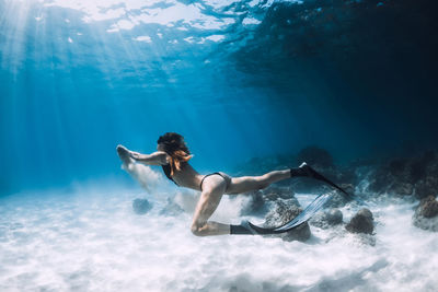 Rear view of woman swimming in sea