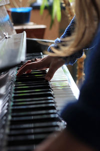 Close-up side view of hand playing the piano