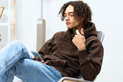 Young man using mobile phone at home