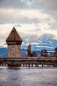 Gazebo by building against sky during winter