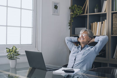Smiling senior woman relaxing at home office
