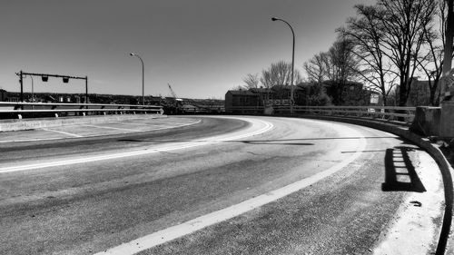 Vehicles on road against sky in city
