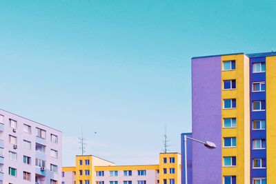 Low angle view of buildings against clear blue sky