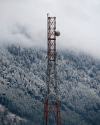 Communications tower against sky during winter