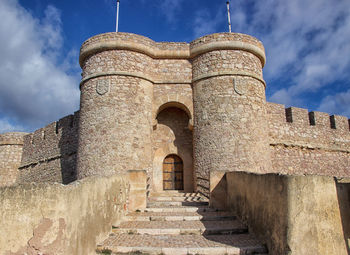 Low angle view of historical castle against cloudy sky