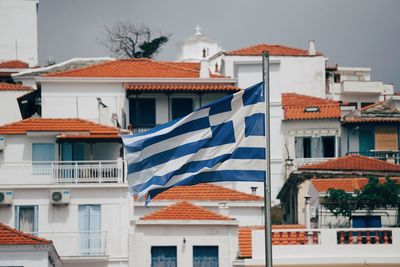 Low angle view of buildings and greek flag in city