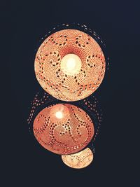 Close-up of illuminated lighting equipment against black background