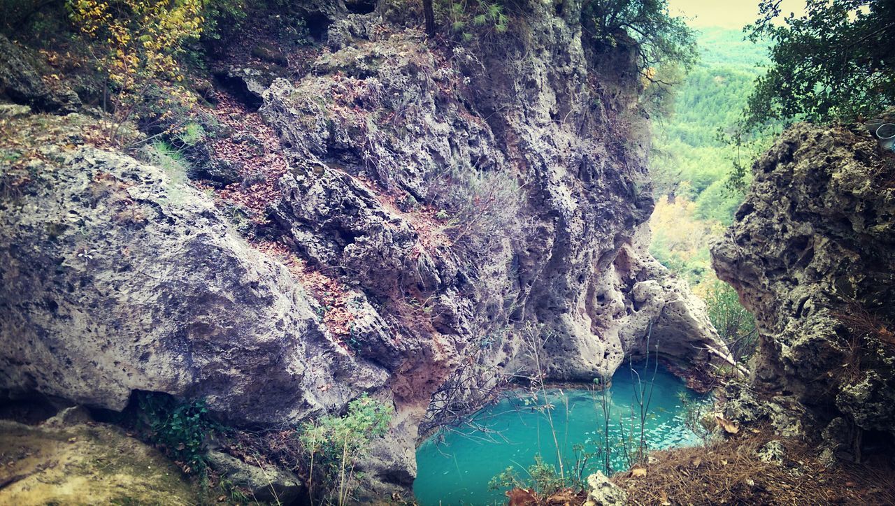 water, tranquility, beauty in nature, nature, tranquil scene, tree, scenics, rock - object, high angle view, rock formation, day, idyllic, non-urban scene, sea, sunlight, outdoors, river, forest, growth, cliff