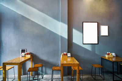 Empty chairs and table against wall