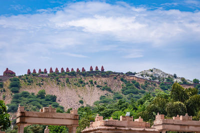 Artistic series or red stone jain temple at mountain top with bright blue sky at morning image