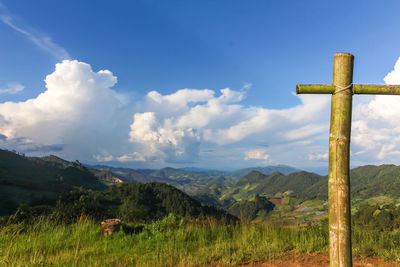 Cross on land against sky