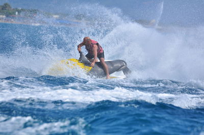 Full length of man riding jet boat in sea