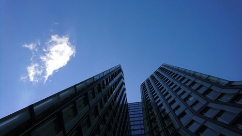 Low angle view of skyscrapers against blue sky