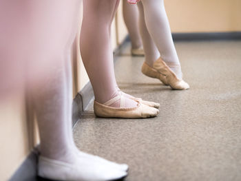 Low section of ballet dancers standing on floor