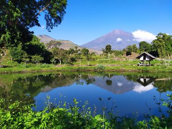 Scenic view of lake and mountains against blue sky