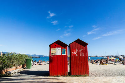 Lifeguard hut on beach against blue sky