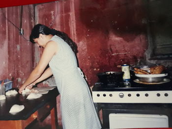 Side view of woman preparing food at home