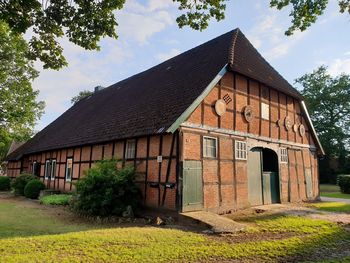 Old building by trees against sky