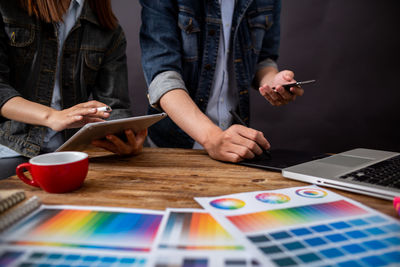 Midsection of woman using mobile phone on table