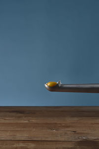 Close-up of fruit on table against blue sky