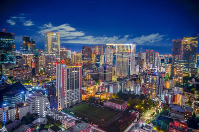 High angle view of illuminated cityscape against sky at night