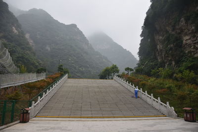 Steps leading towards mountain against clear sky