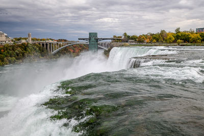 Scenic view of waterfall against sky