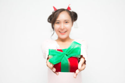 Portrait of young woman standing against white background