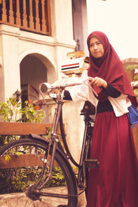 Full length portrait of young woman on her bicycle