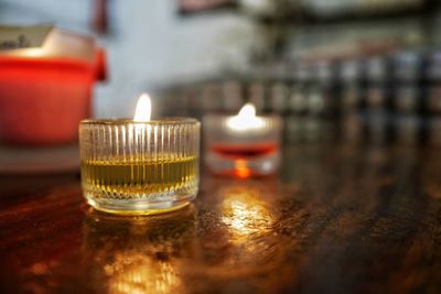 Close-up of lit tea light candles on table